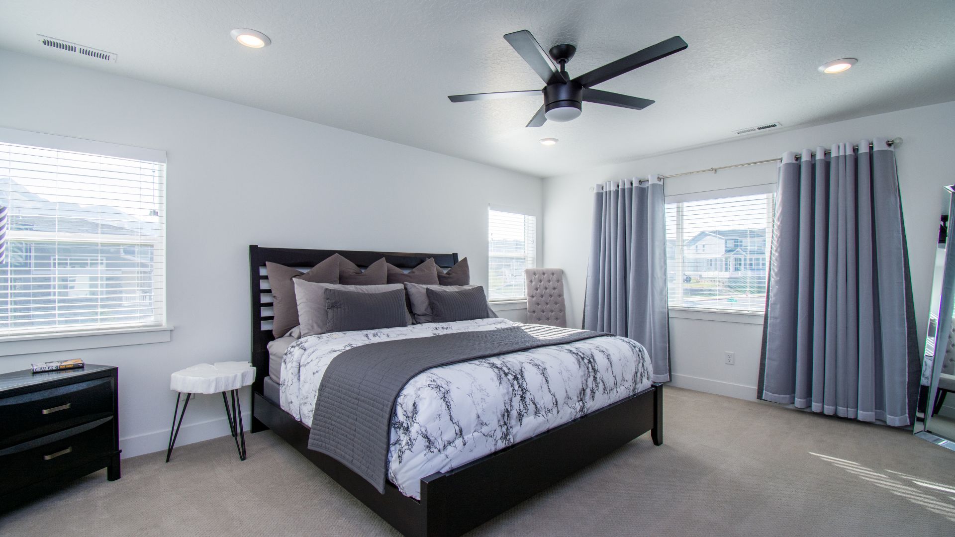 A bedroom with a large bed and a ceiling fan