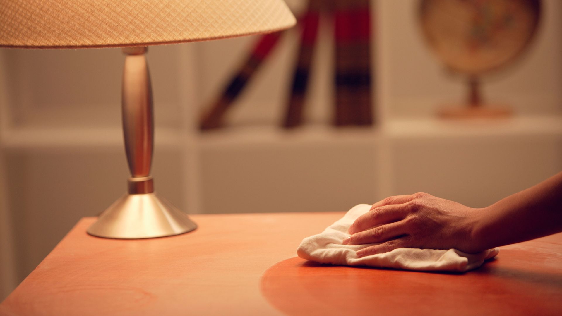 A person wiping a table with a cloth